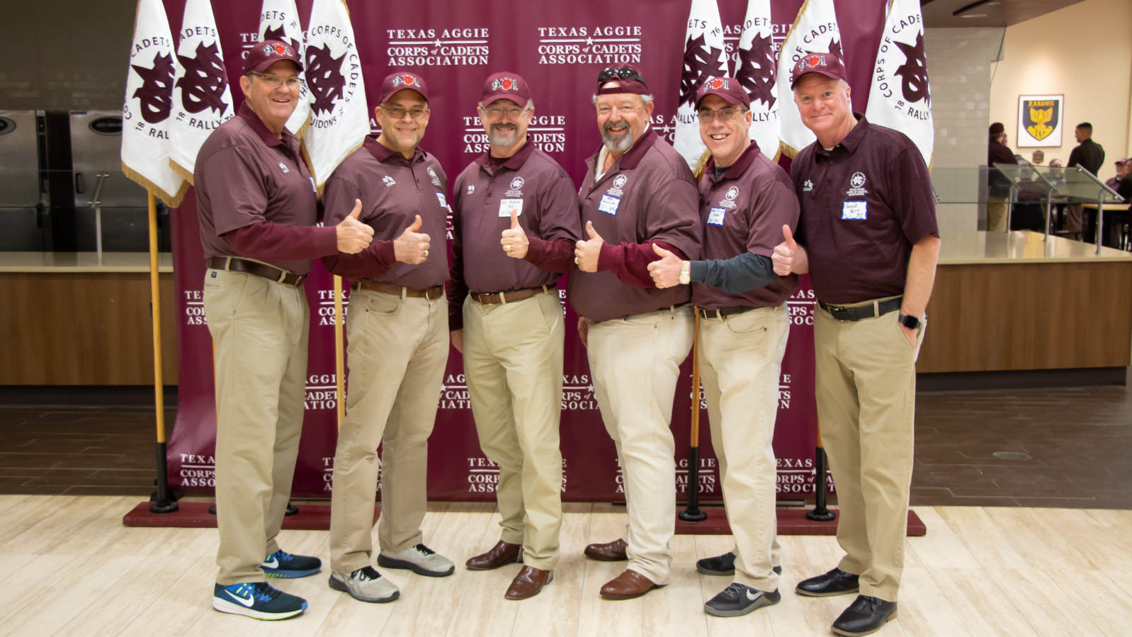 Group photo in front of the Corps of Cadets Association banner